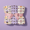 Three Halloween-Themed Blankets Rolled And Tied With A Pink Ribbon.  The Blankets Feature Different Patterns Of Candy, Bats, And Cupcakes.