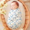 Sleeping Newborn Baby Swaddled In A White Blanket With Light Blue Baby Footprints.