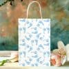 White Gift Bag With A Repeating Pattern Of Light Blue Baby Footprints.