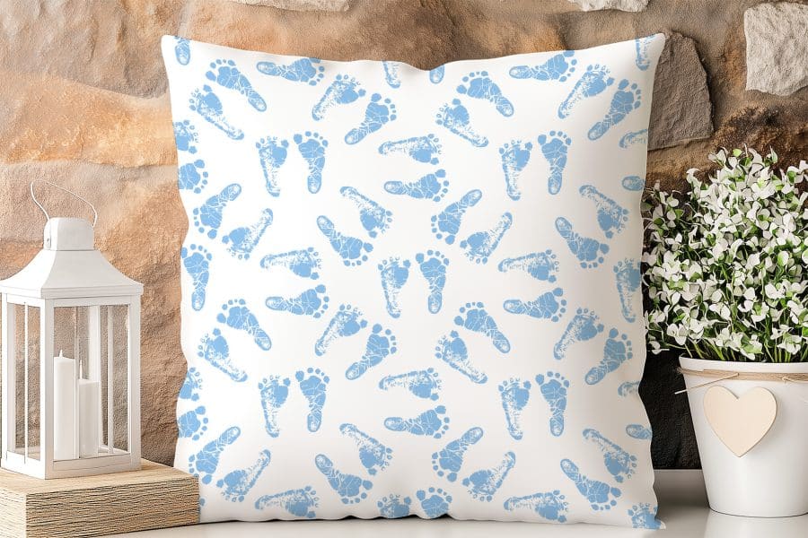 White Pillow With A Pattern Of Light Blue Baby Footprints.