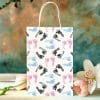 A Gift Bag Decorated With A Repeating Pattern Of Pink, Blue, And Black Baby Footprints.