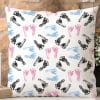 White Square Pillow With A Repeating Pattern Of Black, Pink, And Blue Baby Footprints.