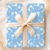 Light Blue Gift Box With A Beige Ribbon, Wrapped In Baby Footprints Pattern.