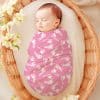 Sleeping Baby Swaddled In A Pink Baby Wrap With A White Footprint Pattern.