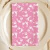 Pink Napkin With A White Baby Footprint Pattern On A Plate.