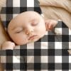 Sleeping Baby Wearing A Black And White Buffalo Plaid Outfit.