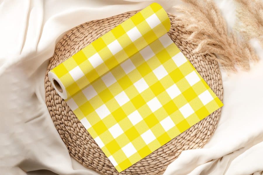 Roll Of Yellow And White Gingham Fabric On A Woven Mat.