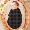 Sleeping Baby Swaddled In A Dark Gray And Black Plaid Blanket.