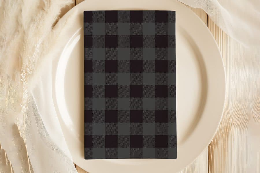 Black And Gray Plaid Napkin On A Beige Plate.