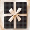A Black And Gray Plaid Gift Box With A Beige Ribbon.