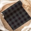 A Roll Of Dark Gray And Black Buffalo Plaid Fabric.