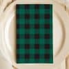 Green And Black Buffalo Plaid Napkin On A White Plate.