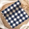 Roll Of Navy Blue And White Gingham Fabric On A Woven Mat.