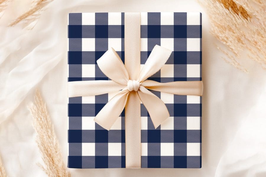 A Navy Blue And White Gingham Gift Box Tied With A Beige Ribbon.