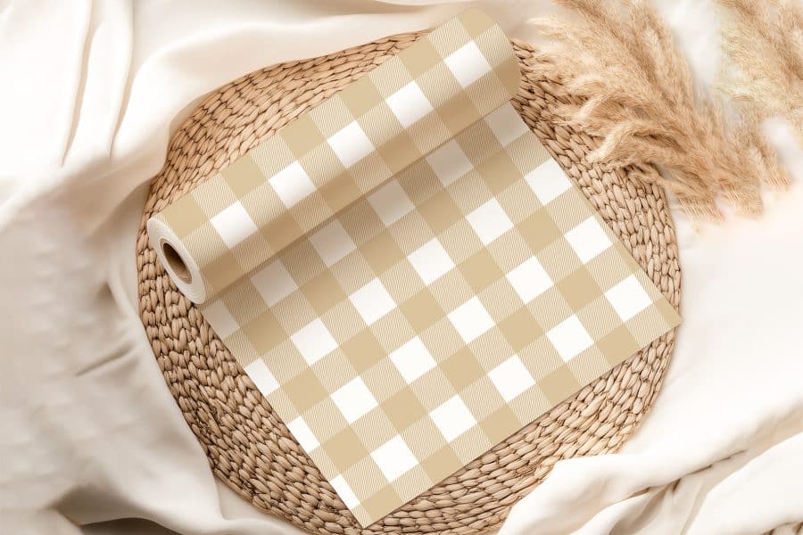 Beige And White Gingham Patterned Wrapping Paper Roll On A Woven Mat.