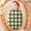 Sleeping Baby Swaddled In A Green And White Gingham Blanket.