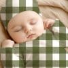 Sleeping Baby Wearing A Green And White Buffalo Plaid Outfit.