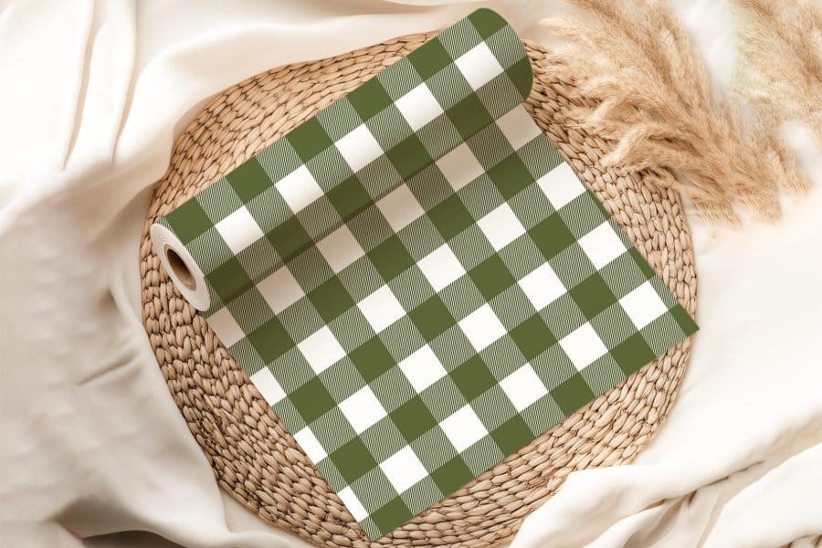 A Roll Of Olive Green And White Gingham Fabric On A Woven Placemat.