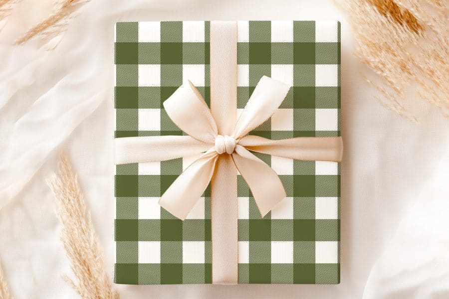 A Gift Wrapped In Olive Green And White Buffalo Plaid With A Beige Ribbon.