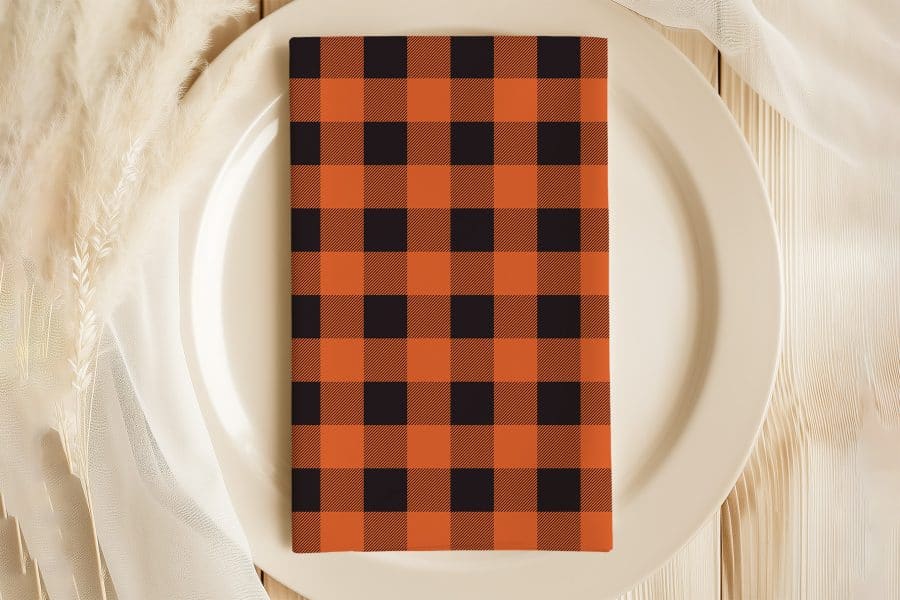 Orange And Black Checkered Napkin On A White Plate.