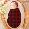 Sleeping Baby Swaddled In A Red And Black Buffalo Plaid Blanket.