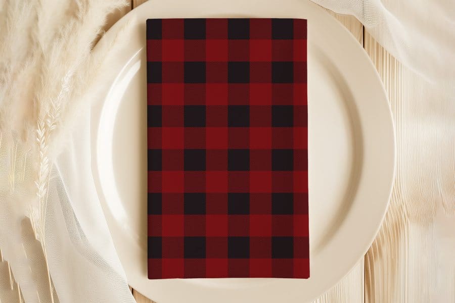 Red And Black Buffalo Plaid Napkin On A White Plate.