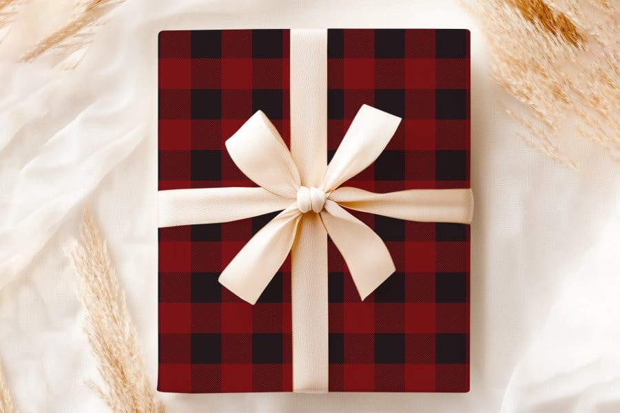 A Red And Black Buffalo Plaid Gift Box With A Cream-Colored Ribbon.