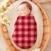 Sleeping Baby Swaddled In A Pink And Burgundy Plaid Blanket.