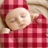 Sleeping Baby Wearing A Red And Pink Plaid Outfit.