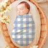 Sleeping Baby Swaddled In A Blue And White Gingham Blanket.