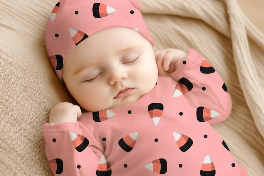 Sleeping Baby Wearing A Pink Candy Corn Onesie And Matching Hat.