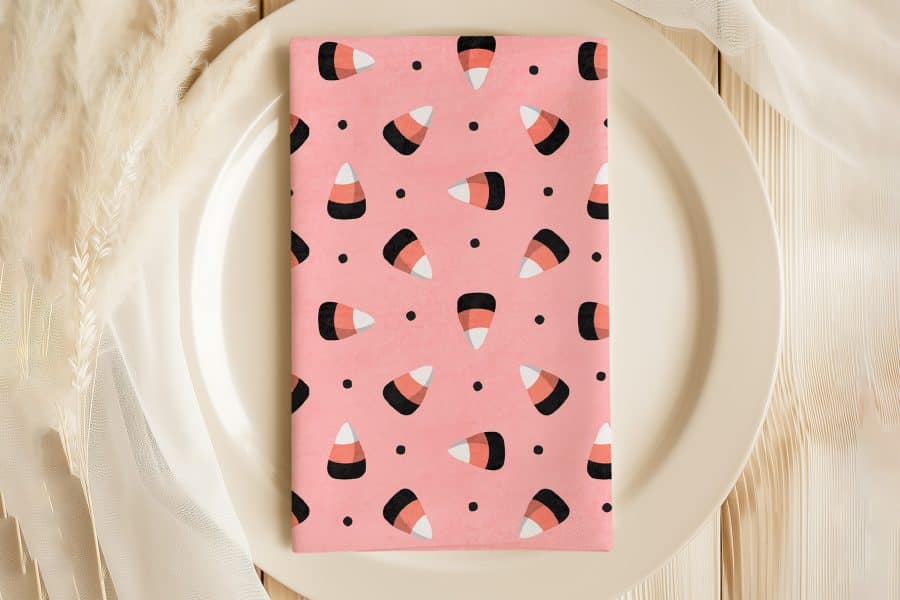 Pink Napkin With A Repeating Pattern Of Candy Corn.