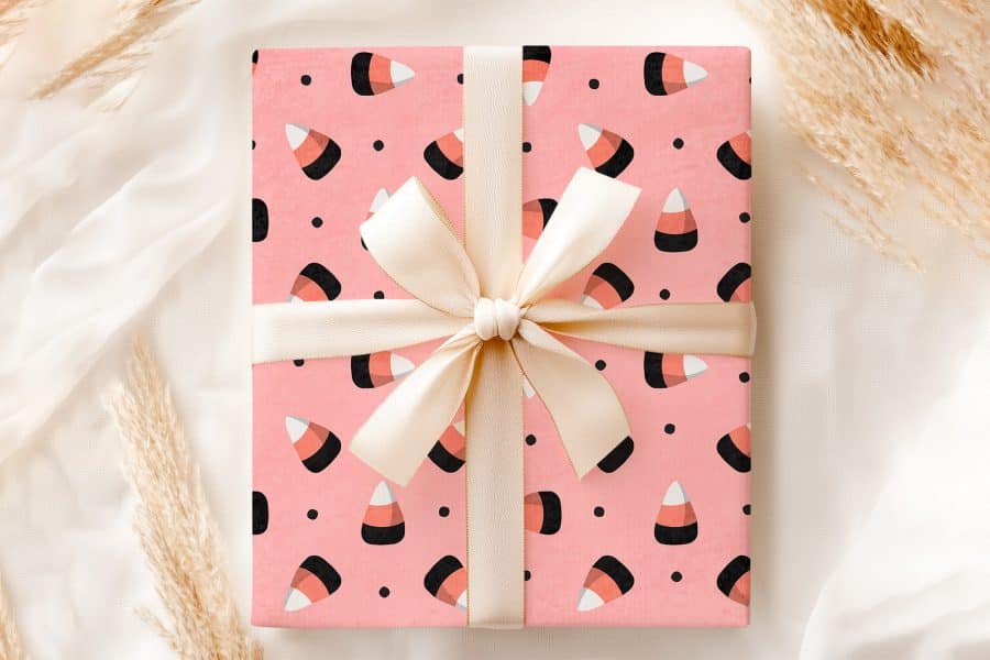 Pink Gift Box With Candy Corn Pattern And Beige Ribbon.