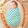 Sleeping Baby Swaddled In A Teal And White Checkered Blanket.