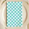 A Teal And White Checkered Napkin On A Beige Plate.