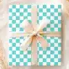 A Light Teal And White Checkered Gift Box With A Beige Ribbon.
