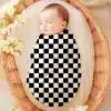 Sleeping Baby Swaddled In A Black And White Checkered Wrap.