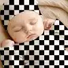 Sleeping Baby Wearing A Black And White Checkered Hat And Outfit.