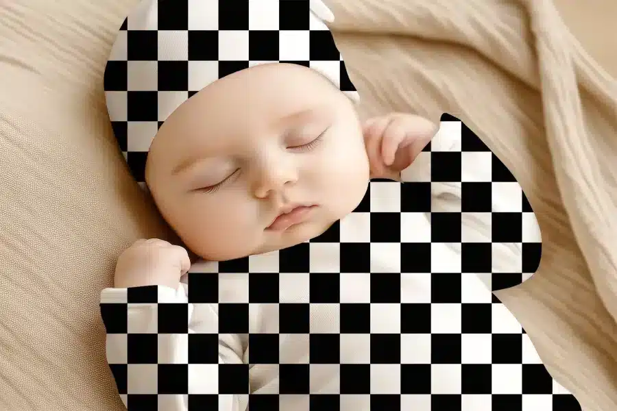 Sleeping Baby Wearing A Black And White Checkered Hat And Outfit.