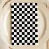 A Black And White Checkered Napkin On A Beige Plate.