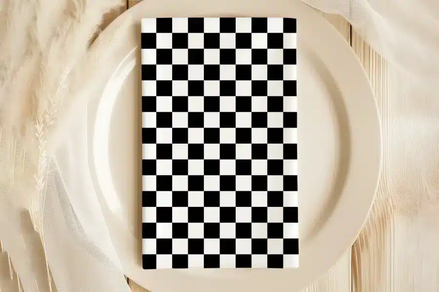 A Black And White Checkered Napkin On A Beige Plate.