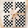 A Gift Box With A Black And White Checkered Pattern And A Beige Ribbon.
