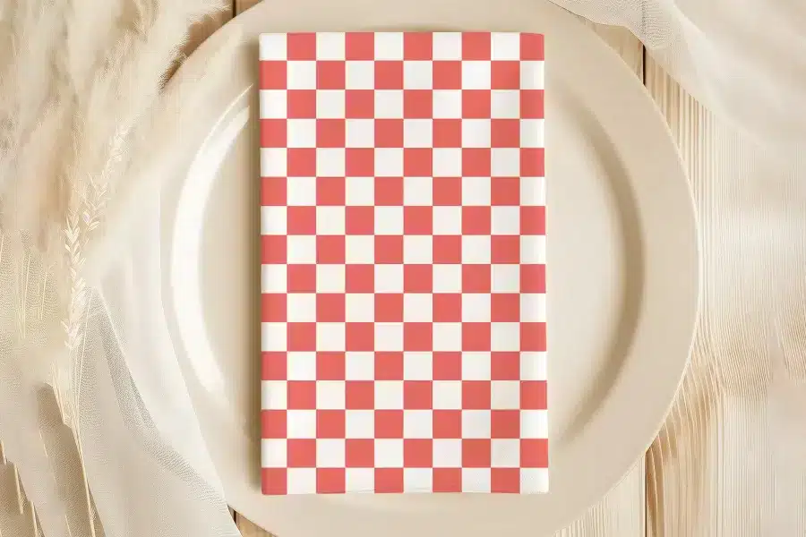 Coral And White Checkered Napkin On A Beige Plate.