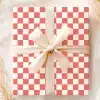 A Coral And White Checkered Gift Box With A Beige Ribbon.