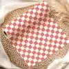Coral And White Checkered Wrapping Paper Roll On A Woven Mat.