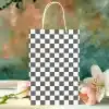 Checkered Paper Shopping Bag In Front Of Flowers.
