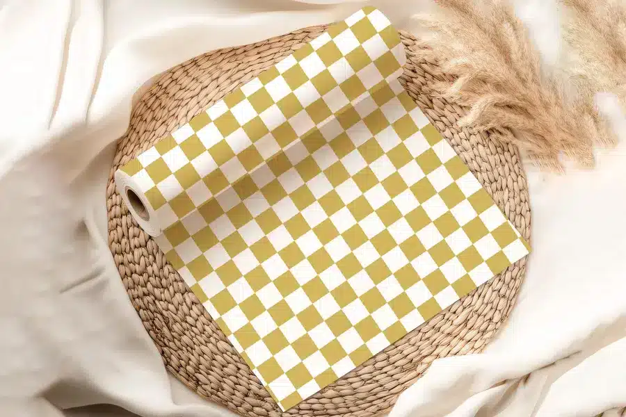 A Roll Of Mustard Yellow And White Checkered Wrapping Paper On A Woven Mat.