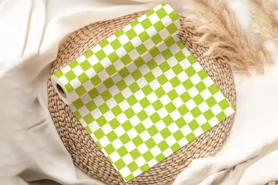 A Roll Of Lime Green And White Checkered Wrapping Paper On A Woven Placemat.