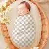 Sleeping Baby Swaddled In A Fabric Wrap Inside A Wicker Basket.