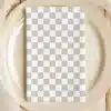 A Beige Plate With A Gray And White Checkered Napkin.